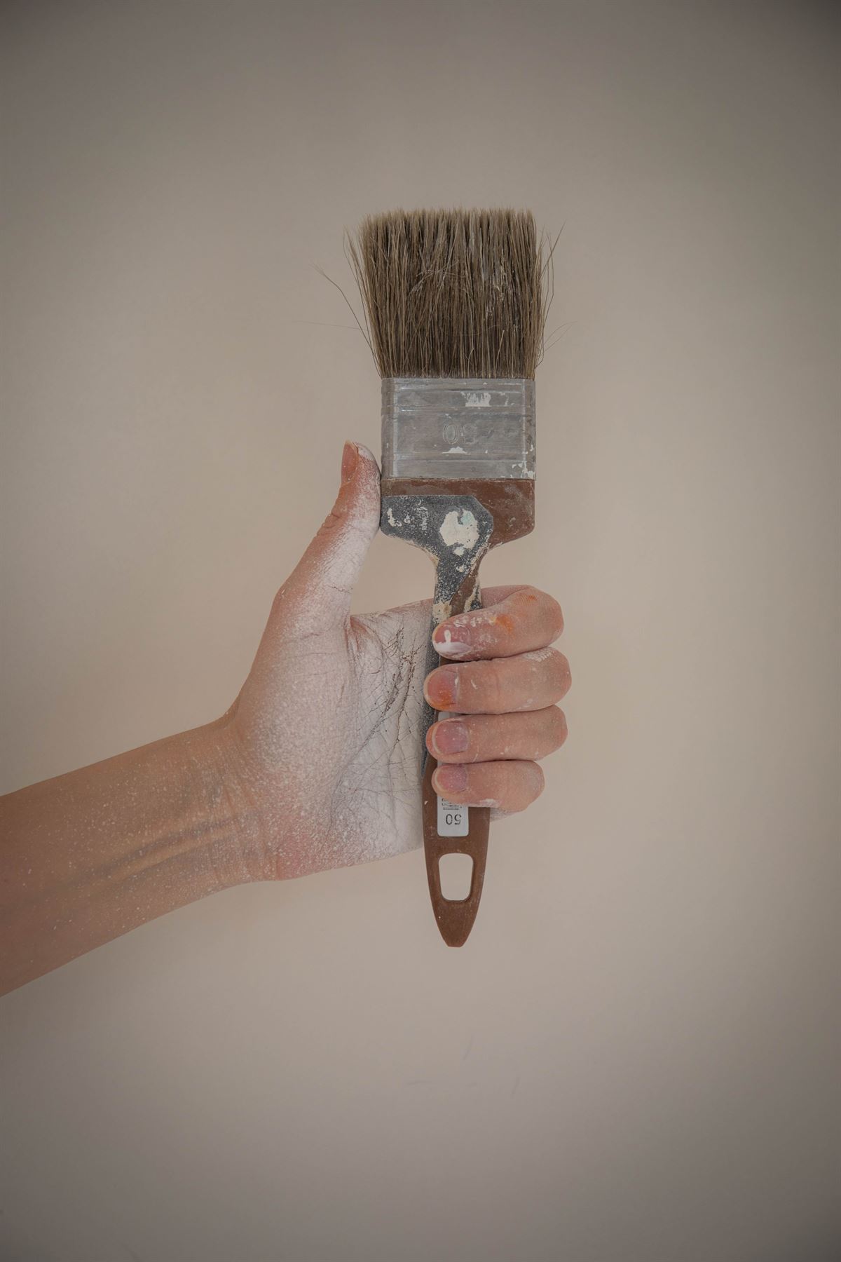 Hand hält einen gebrauchten Pinsel